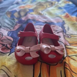 Mini Melissa red shoe with a tan bow